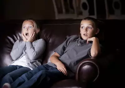 two young children watching shocking movie in a Gatlinburg cabin rental