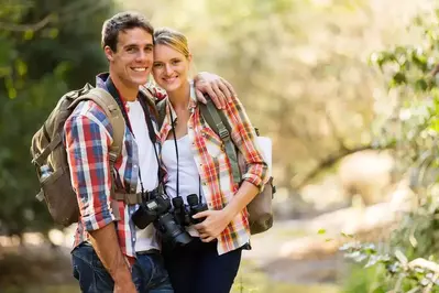 Young couple with backpacks and binoculars on a hike in the Smoky Mountains
