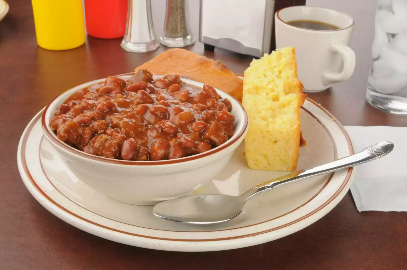 Bowl full of beans with cornbread on a plate