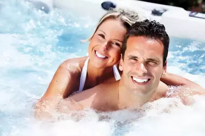 Young couple in a bubbling hot tub while on vacation in Gatlinburg cabin