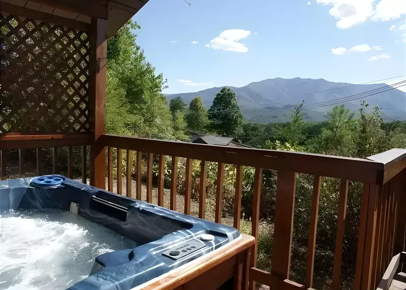 A hot tub on the deck of a cabin with beautiful mountain views